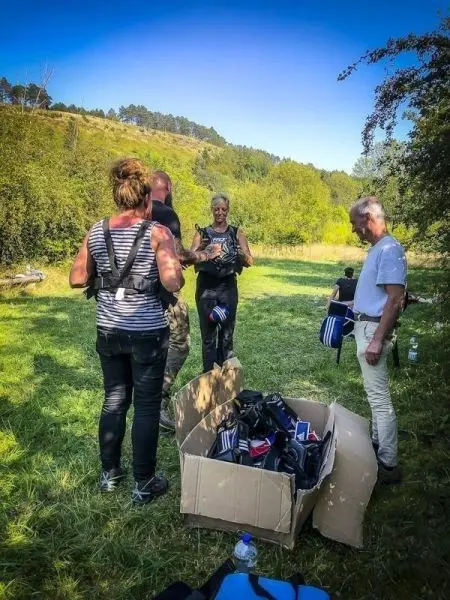 Personen prüfen Sicherheitsgurte aus einem Karton auf einer Wiese