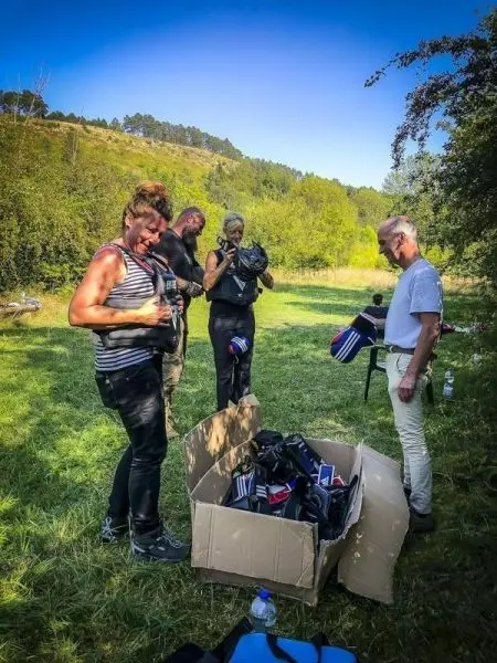 Personen sortieren Ausrüstung aus einem Karton im Freien