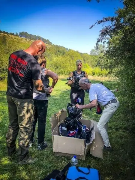 Personen sortieren Ausrüstung aus einem Karton im Freien