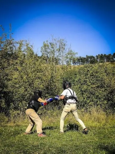 Zwei Kämpfer im Boxtraining tragen Schutzausrüstung und kämpfen im Freien