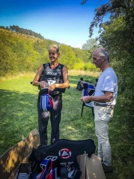 Zwei Personen sortieren Ausrüstung aus einer offenen Box auf einer Wiese