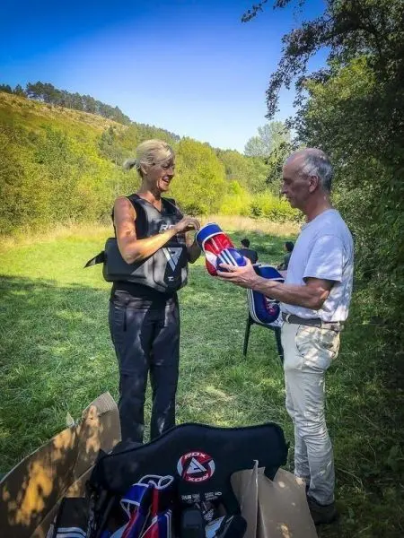 Zwei Personen stehen auf einer Wiese und halten Boxhandschuhe in der Hand