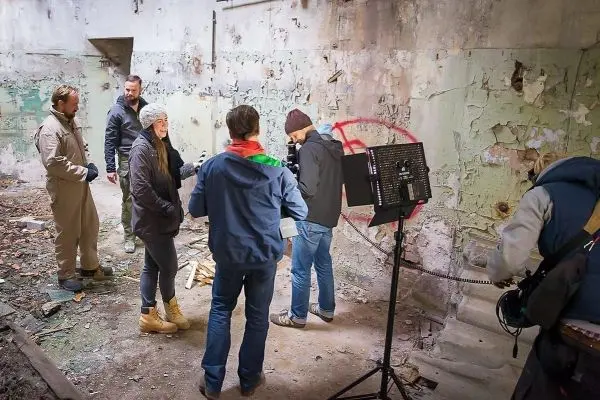 Gruppe von fünf Personen in einem verlassenen Raum mit Kamera-Equipment und Beleuchtung
