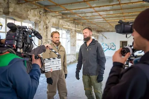 Kamera-Team filmt Szene mit Klappe in leerem Raum