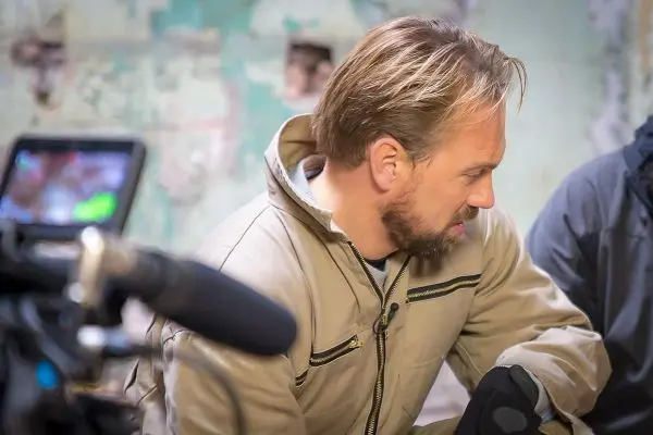 Kamera und Mikrofon sind auf einen Mann gerichtet, der nachdenklich sitzt