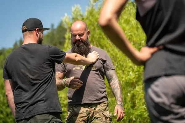 Ein Teilnehmer demonstriert eine Technik zur Selbstverteidigung an einem anderen