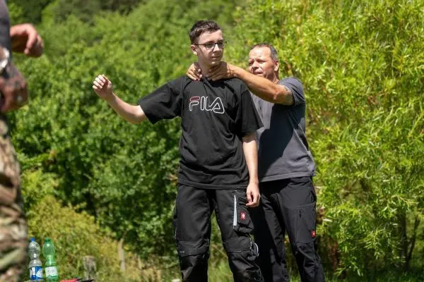 Ein Trainer demonstriert eine Technik an einem Teilnehmer während einer Übung