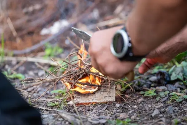 Feuerstahl erzeugt Funken auf Zunder aus Ästen und Rinde