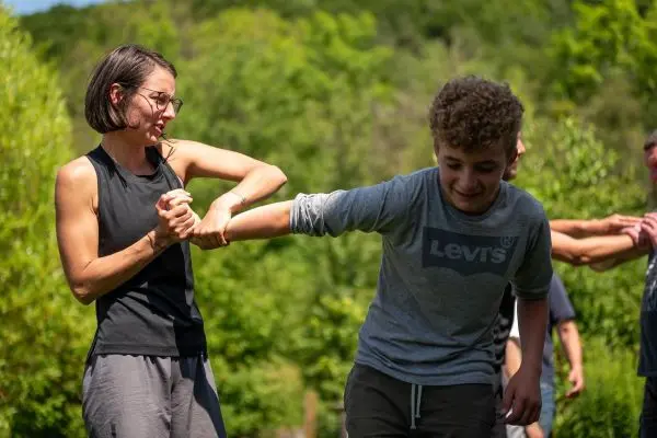 Frau hält Arm eines Jungen während einer Übung im Freien