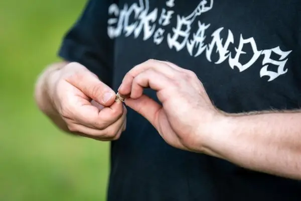 Hände halten einen kleinen Gegenstand und bereiten ihn zur Verwendung vor