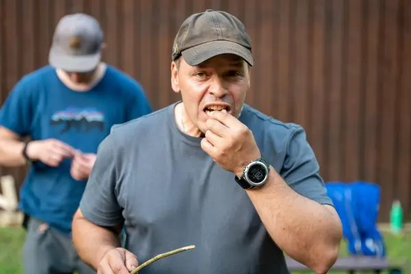 Holzstück wird zum Essen in den Mund geführt