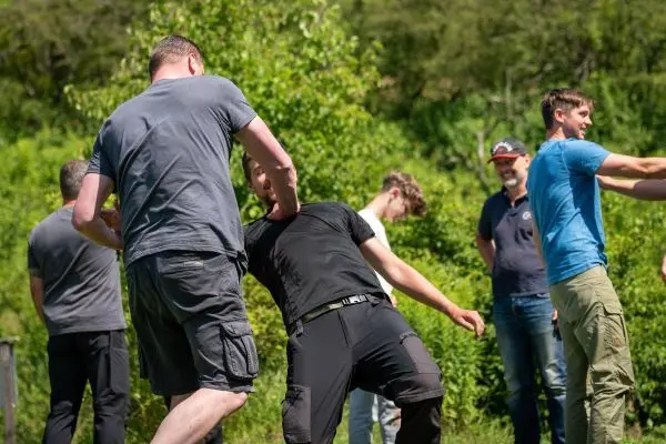 Kampfsportübung mit zwei Teilnehmern in einer grünen Umgebung