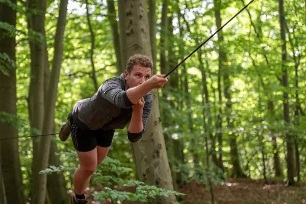 Körpergewicht wird an einem Seil in einem Wald nach vorne gezogen