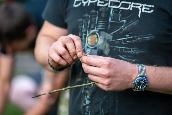 Person bearbeitet einen dünnen Stock mit beiden Händen