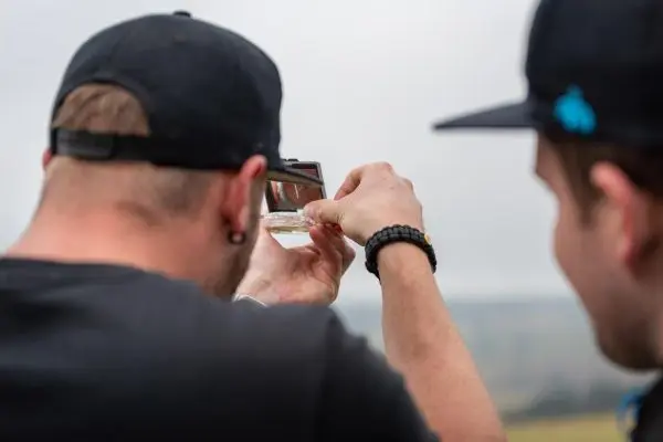Person hält ein Glas mit Flüssigkeit und betrachtet es