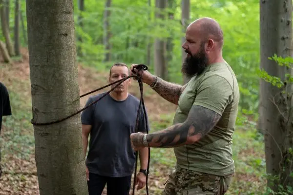 Seil wird um einen Baumstamm geschlungen und gesichert