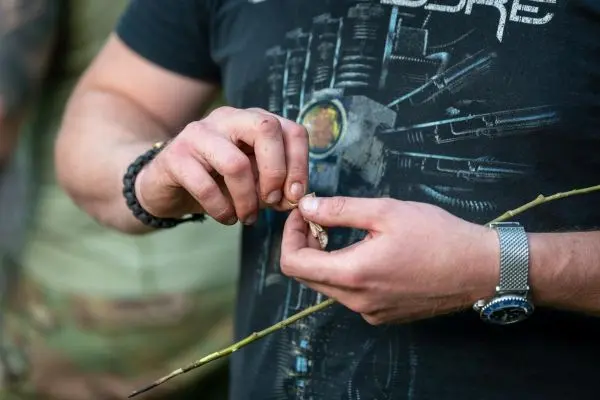 Zunder wird aus einem Zweig herausgekratzt