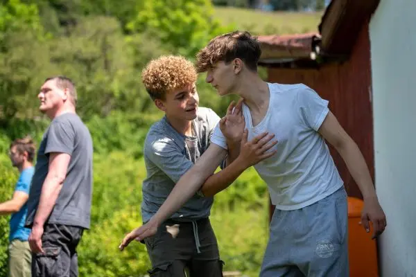 Zwei Jugendliche üben eine körperliche Technik in einer Trainingssituation