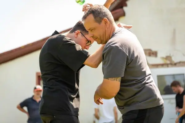 Zwei Personen üben eine Selbstverteidigungstechnik im Freien