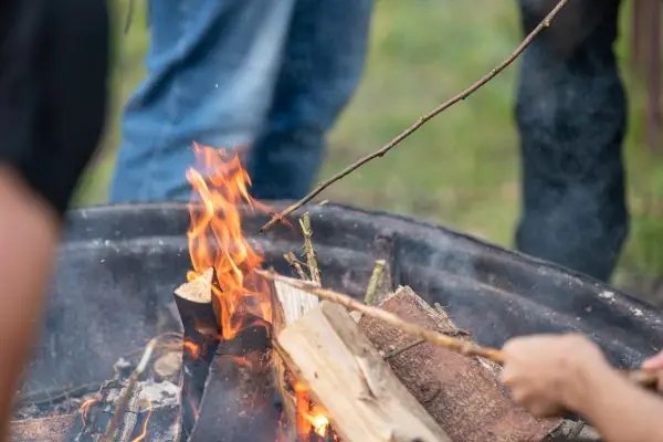 Zweig wird in ein brennendes Feuer gelegt
