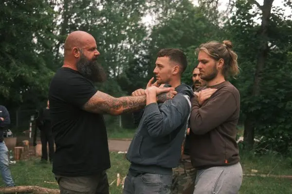 Ein Trainer demonstriert eine Technik zur Selbstverteidigung an einem Teilnehmer