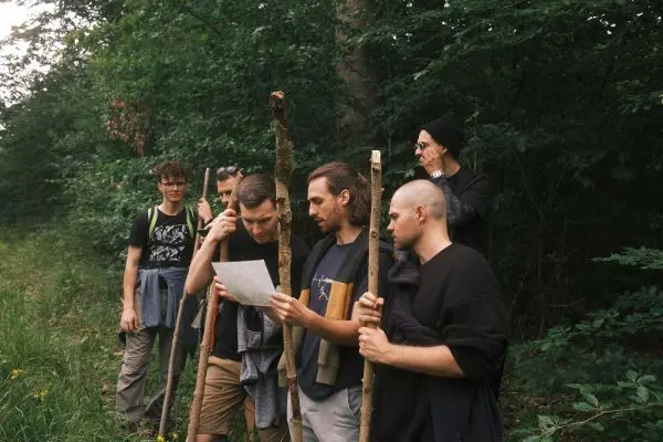 Gruppe von Personen betrachtet eine Karte im Wald beim Überlebenstraining