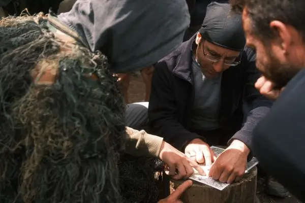 Zwei Personen studieren eine Karte auf einem Baumstumpf