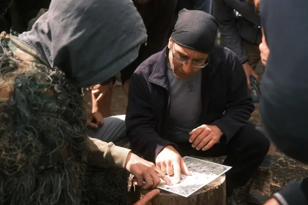 Zwei Personen studieren eine Karte auf einem Baumstumpf im Freien