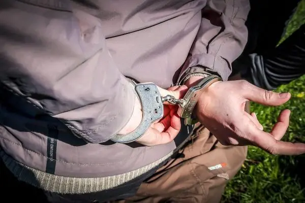 Handschellen sind an den Handgelenken einer Person befestigt