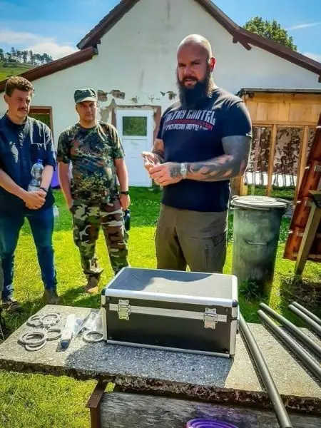 Ein Mann erklärt Ausrüstung vor einer Gruppe, Werkzeug und Koffer auf dem Tisch