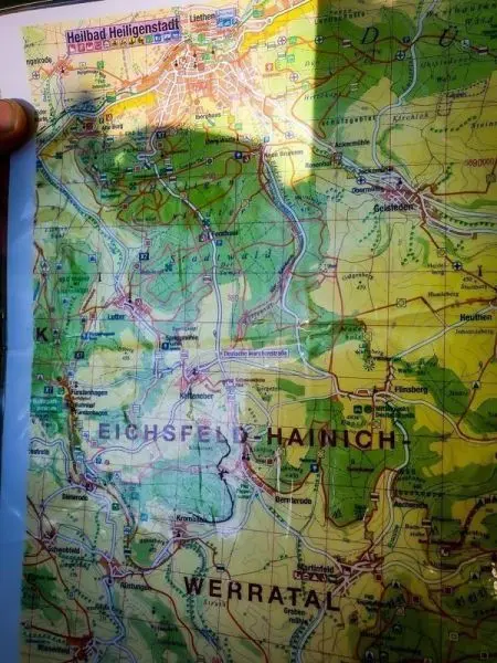 Eine Hand hält eine detaillierte topografische Karte mit verschiedenen Farben
