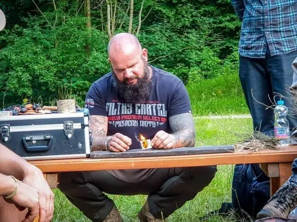 Feuerstahl erzeugt Funken auf Zunder auf einem Tisch im Freien
