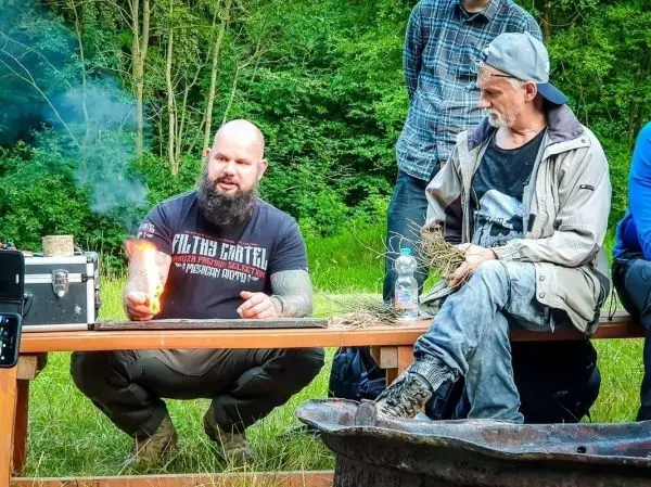 Feuerstahl erzeugt Funken über Zunder auf einem Tisch im Freien