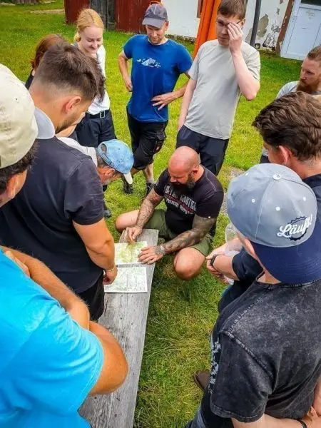 Gruppe betrachtet Karte auf einer Holzbank im Freien