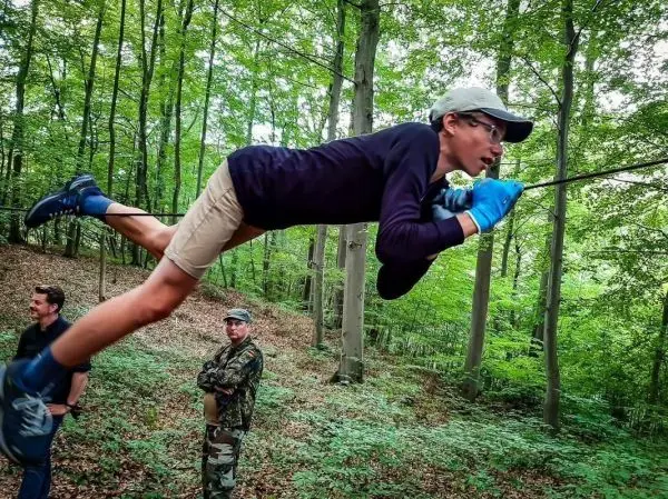 Junge schwingt an einer Seilbrücke durch den Wald