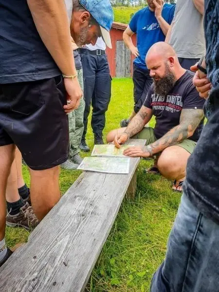 Karte wird auf einer Holzbank von mehreren Personen studiert