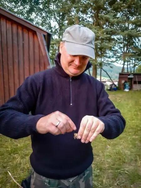 Mann hält eine kleine lebende Kreatur in den Händen