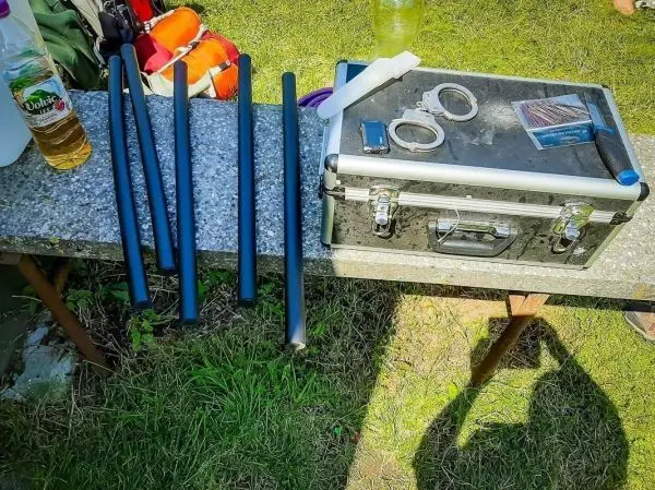 Schwarze Rohre und Werkzeugkiste auf einem Tisch im Freien