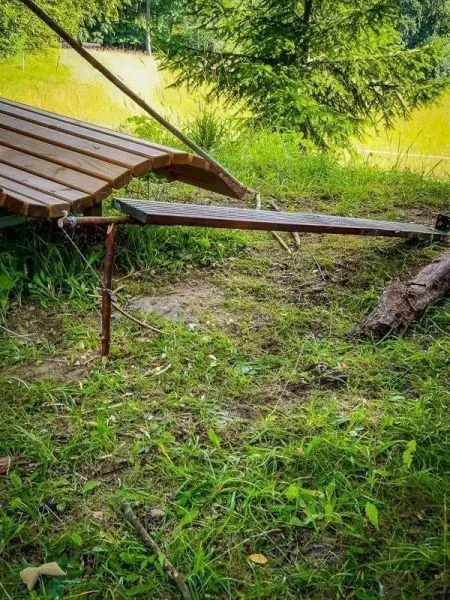 Selbstgebaute Seilbrücke aus Holz und Metallteilen im Gras