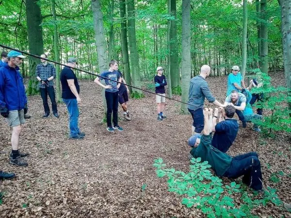 Teilnehmer üben den Einsatz einer selbstgebauten Seilbrücke im Wald