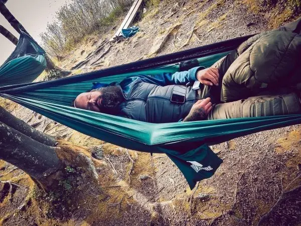 Hängematte zwischen Bäumen mit schlafender Person im Outdoor-Bereich