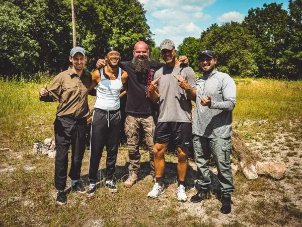 Fünf Personen stehen in einer Wiese und zeigen Daumen hoch