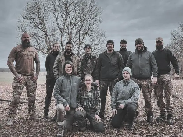 Gruppe von Personen posiert im Freien vor einem Baum