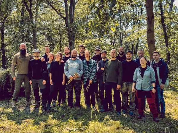 Gruppe von Personen steht im Wald und posiert für ein Foto