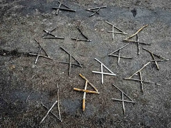 Holzstöcke liegen in Form von Kreuzen auf dem Boden