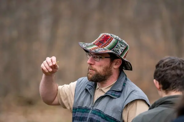 Mann hält ein kleines Objekt in der Hand und spricht mit einer anderen Person