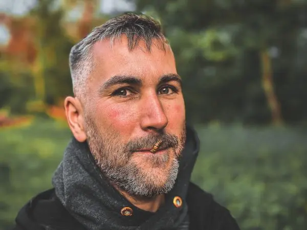 Person lächelt mit einem Stift im Mund