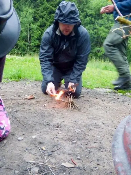 Feuerstahl entzündet Zunder in einer kleinen Feuerstelle