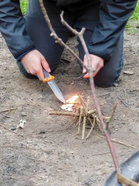 Feuerstahl erzeugt Funken auf Zunder in einer Holzansammlung