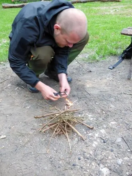 Feuerstahl erzeugt Funken auf Zunderhaufen aus Ästen